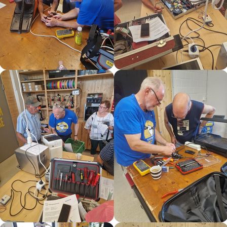 Eine Gruppe von Menschen arbeitet an verschiedenen elektronischen Geräten. Ein Mann untersucht eine Leiterplatte. Ein anderer benutzt ein Multimeter. Ein weiterer lötet Drähte. Eine vierte Person steht und beobachtet.