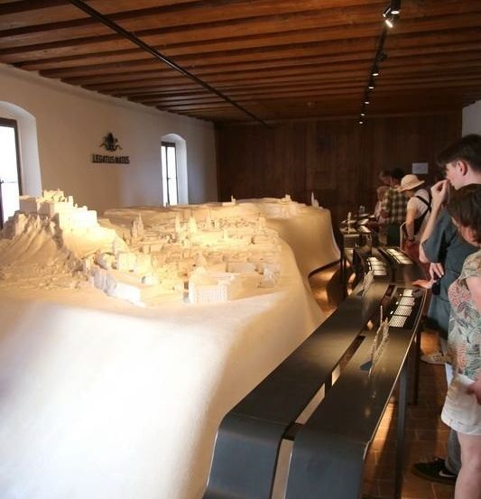 Bild enthält, Plywood, Wood, Lighting, Person, Indoors, Museum, Sword, Shorts, Flooring, Hat