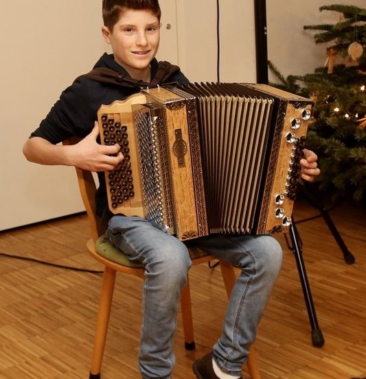 Bild enthält, Person, Sitting, Solo Performance, Wood, Footwear, Shoe, Musical Instrument, Face, Photography, Portrait