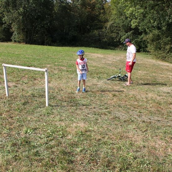 Bild enthält, Soccer Ball, Grass, Helmet, Person, Hat, Shoe, Bicycle, Field, People, Sphere