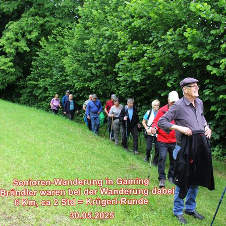 Eine Gruppe von Menschen wandert auf einem Grasweg, angeführt von einem lächelnden Mann in einem Hut. Die Gruppe wanderte etwa 6 Kilometer oder ungefähr 2 Stunden und bildete eine Rundstrecke. Datum: 30.05.2025.