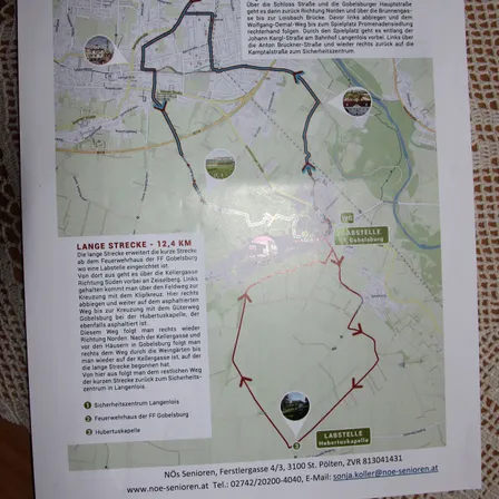 Eine Wanderkarte zeigt eine Route namens Lange Strecke, 12,4 km, die von FF Gobelsburg startet. Die Route führt über Schloss Straße, entlang der Gobelsburger Hauptstraße, dann links auf den Loisbach-Weg zum Spielplatz Promenadensiedlung. Sie folgt dann der Johann Karoli-Straße und verläuft weiter entlang des Bahnhofs Langelndorf. Links führen zur Johann Bruckner-Straße und weiter zum Campingplatz.