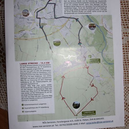 Eine Wanderkarte zeigt eine Route namens Lange Strecke, 12,4 km, die von FF Gobelsburg startet. Die Route führt über Schloss Straße, entlang der Gobelsburger Hauptstraße, dann links auf den Loisbach-Weg zum Spielplatz Promenadensiedlung. Sie folgt dann der Johann Karoli-Straße und verläuft weiter entlang des Bahnhofs Langelndorf. Links führen zur Johann Bruckner-Straße und weiter zum Campingplatz.