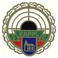 Ein kreisförmiges Emblem mit einem Seilrand, das einen zentralen schwarzen Kreis, grüne und rote Streifen und einen blauen Schild mit einem Gebäudesymbol aufweist. Der Schriftzug 'KAPPLG' steht in fetten Buchstaben über dem Schild.