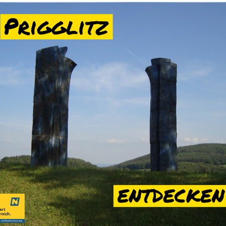 Zwei hohe blaue Skulpturen stehen auf einem Rasenfeld unter einem blauen Himmel. Die Wörter 'Prigglitz' und 'Entdecken' sind in Gelb geschrieben.