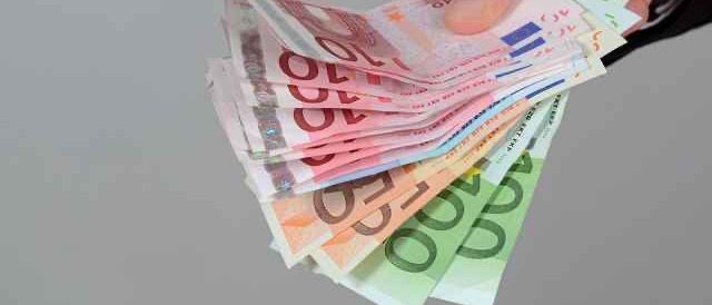 Nahaufnahme einer Hand, die eine Handvoll Euro-Banknoten hält, darunter 5, 10, 20, 50 und 100 Euro Scheine.