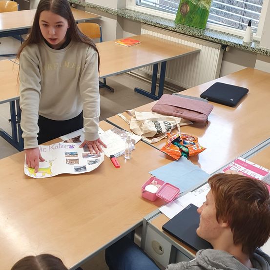 Bild enthält, Person, Student, Adult, Female, Woman, Table, Face, Head, Handbag, Text
