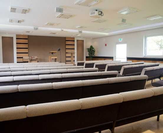 Bild enthält, People, Indoors, Crowd, Classroom, School, Audience, Lecture, Hall, Lecture Hall, Couch