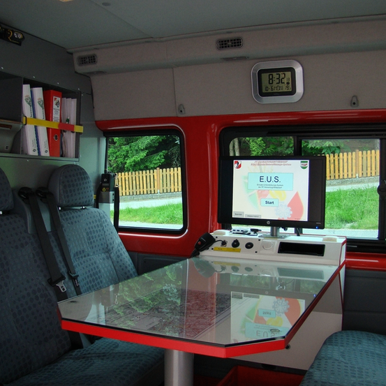 Bild enthält, Furniture, Table, Cushion, Home Decor, Computer Hardware, Monitor, Screen, Car, Couch, Bus