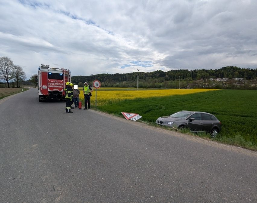Ein Auto steht am Straßenrand mit Feuerwehrleuten in der Nähe. Ein Feuerwehrwagen ist anwesend mit einem Schild, das eine Geschwindigkeitsbegrenzung von 16 km/h anzeigt.