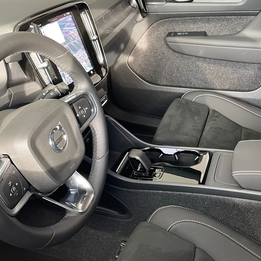 Innenraum eines Volvo-Autos mit Lenkrad, Armaturenbrett und Vordersitzen.