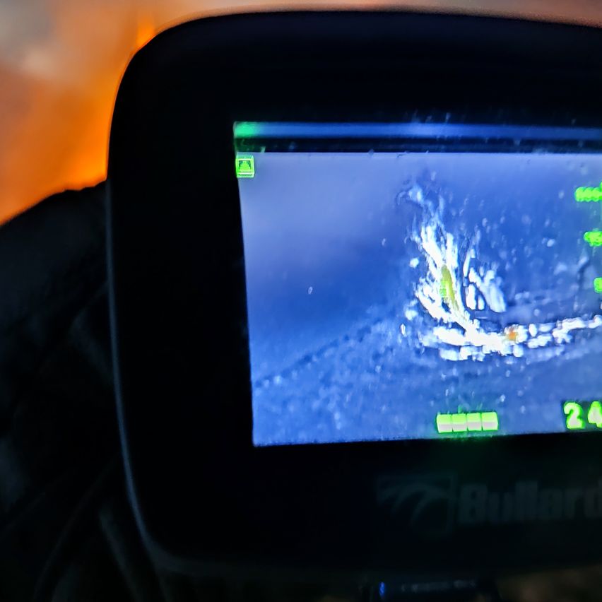 Ein Kamerabildschirm zeigt einen Fisch, der unter Wasser schwimmt. Der Bildschirm zeigt eine Tiefe von 24 Fuß an.