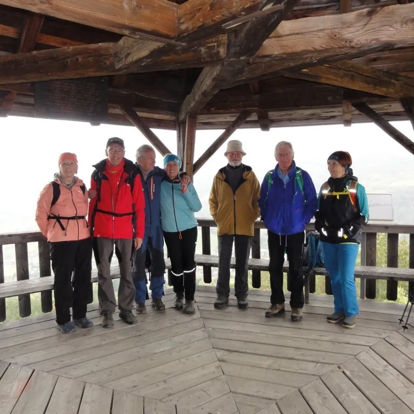 Wandergruppe in Holzhütte mit Bergpanorama