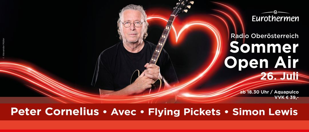 Ein Mann mit Brille hält eine Gitarre und schaut nach vorne. Die Gitarre hat herzförmige rote Lichter im Hintergrund.