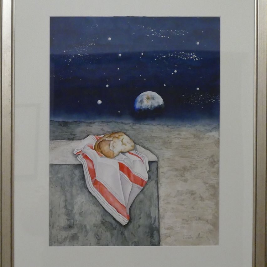 Ein gerahmtes Gemälde zeigt ein Brot auf einem Tuch, das auf einem Rand unter einem Sternenhimmel mit Mond und Sternen ruht.