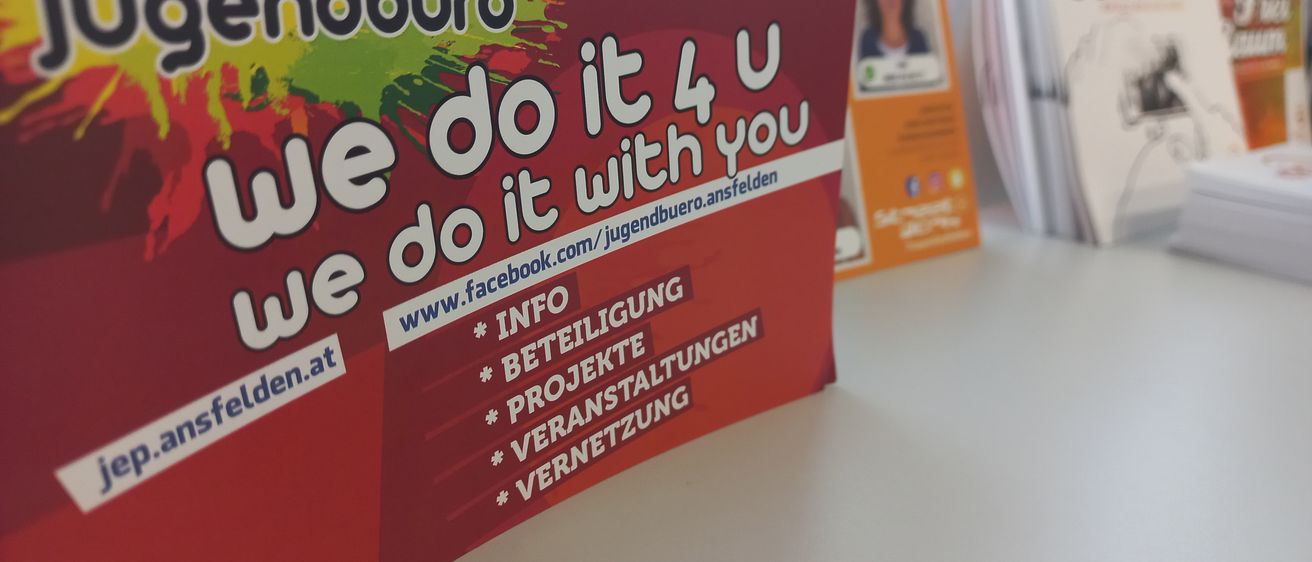 Ein rotes Plakat mit dem Titel Gendburo und weißem Text 'Wir machen es für dich' mit Kontaktinformationen und Social-Media-Symbolen.