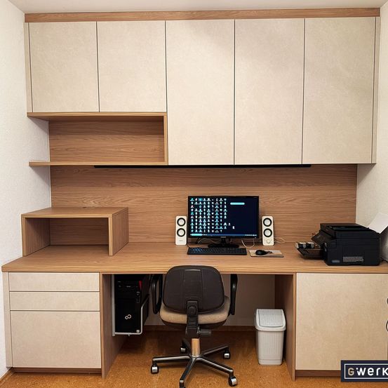 Ein moderner Schreibtisch mit einer Holzoberfläche, ausgestattet mit Computerbildschirm, Tastatur, Maus und Drucker. Der Schreibtisch wird von Holzschränken mit Regalen flankiert, und ein schwarzer Bürostuhl steht davor.