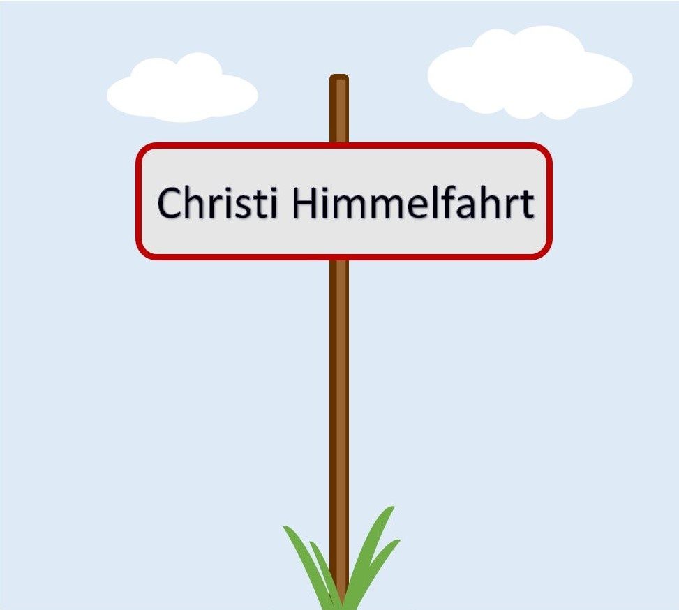 Ein Schild an einem Pfosten mit 'Christi Himmelfahrt' auf blauem Hintergrund und Wolken.