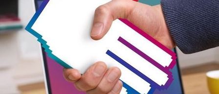 Eine Person gibt einem pixeligen Symbol auf einem Laptop-Bildschirm die Hand, mit einem Bücherregal im Hintergrund.