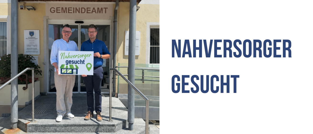 Zwei Männer stehen auf Stufen und halten ein Schild mit der Aufschrift 'nachversorger gesucht'. Sie stehen vor einem Gebäude.
