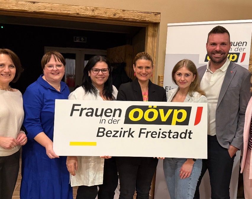 Fünf Frauen stehen mit einem Schild, auf dem 'Frauen in der öövp Bezirk Freistadt' steht, vor einem lächelnden Mann, der in die Kamera schaut.