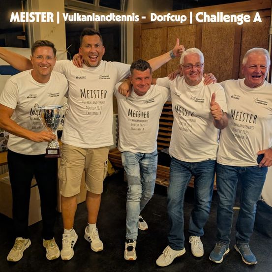 Fünf Männer in weißen T-Shirts mit der Aufschrift Meister stehen zusammen. Sie posieren für ein Foto mit einer Trophäe in der Mitte. Hinter ihnen befindet sich eine Holzwand mit den Worten Meister, Vulkanlandtennis, Dorfcup, Challenge A.