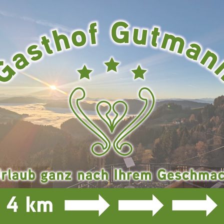Ein Werbebanner für Gasthof Gutmann mit einer malerischen Berglandschaft bei Sonnenuntergang und einem Logo mit Sternen. Der Bannertext lautet 'Erlaub ganz nach Ihrem Geschmack' und '4 km'.