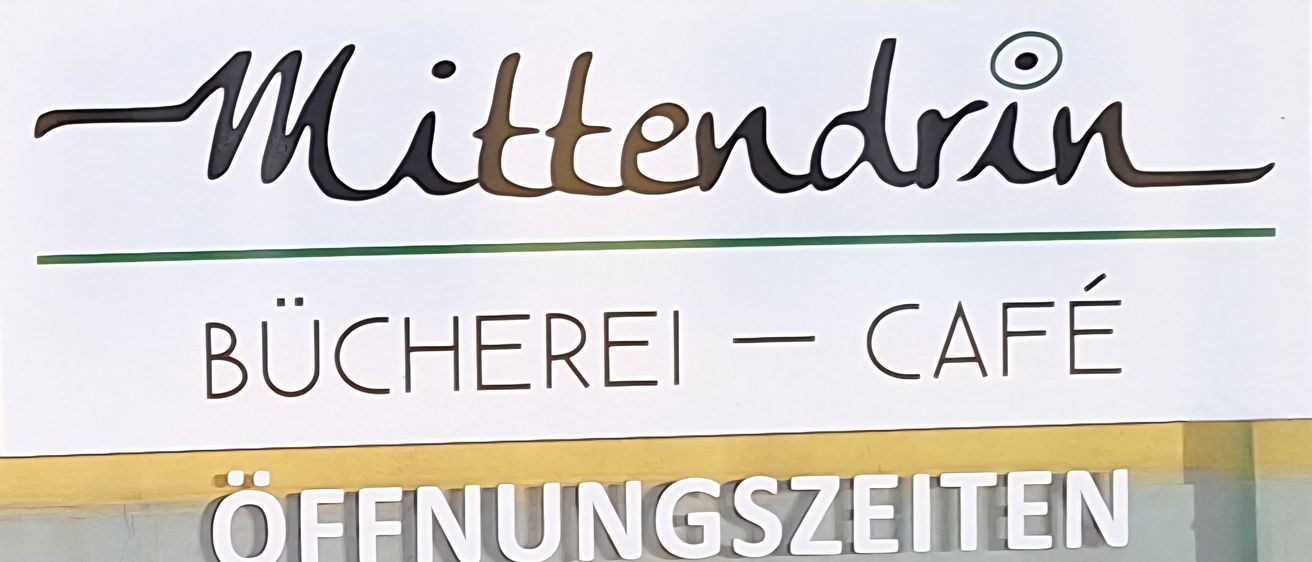 Die Mittendrein Bäckerei und Café hat von 9 Uhr bis 19 Uhr geöffnet. Das Schild hat einen grünen Rand.