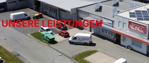 Eine Luftaufnahme eines Gebäudes mit Solarmodulen auf dem Dach. Ein weißer Lieferwagen ist davor geparkt. Das Gebäude hat ein Schild mit der Aufschrift NGEN links und Elektrotechnik Nebel rechts.