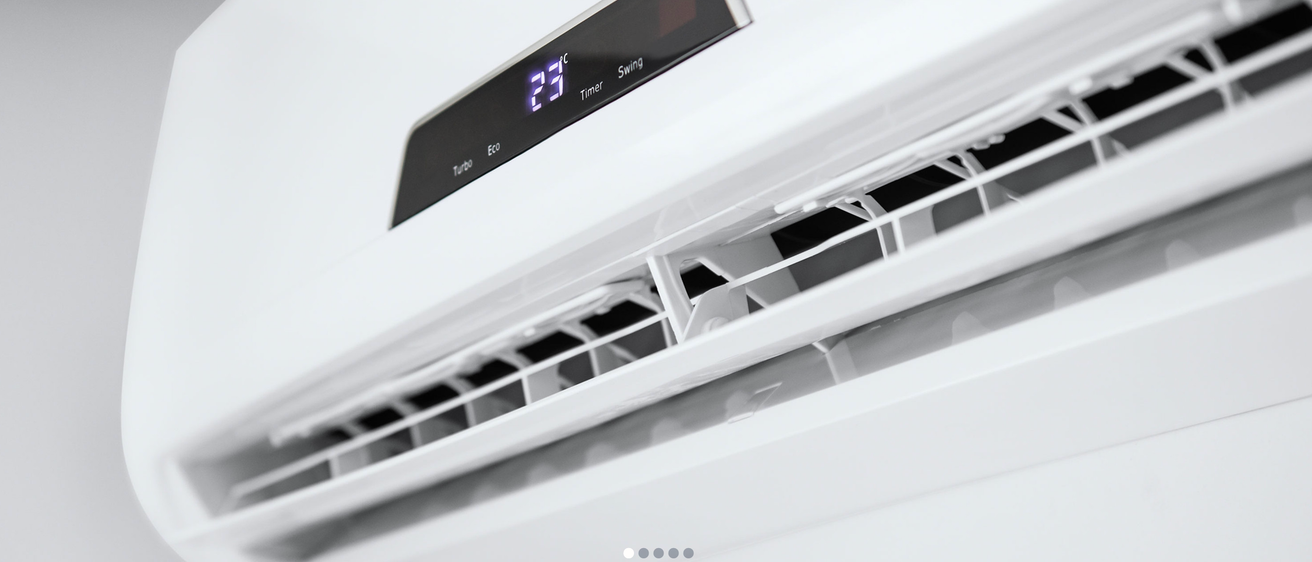 Eine Nahaufnahme einer modernen weißen Klimaanlage mit einem digitalen Display, das 23 Grad Celsius und verschiedene Einstellungen zeigt.