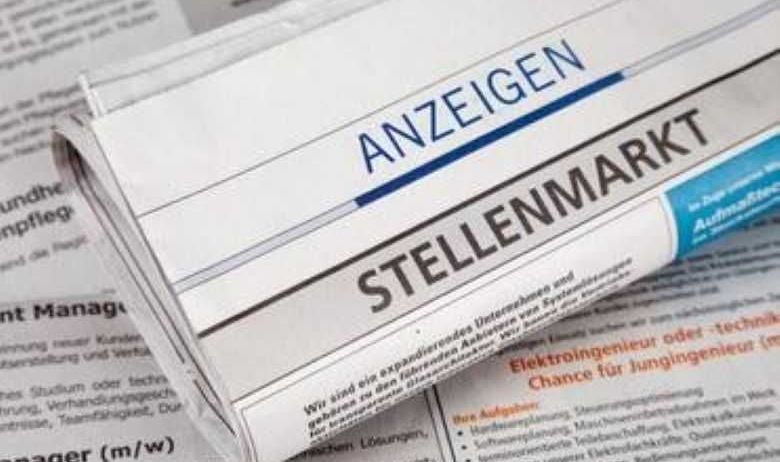 Ein Zeitungsartikel mit dem Titel 'Stellenmarkt' ist teilweise sichtbar, mit Text auf Deutsch. Der Artikel scheint sich um Stellenangebote zu drehen.