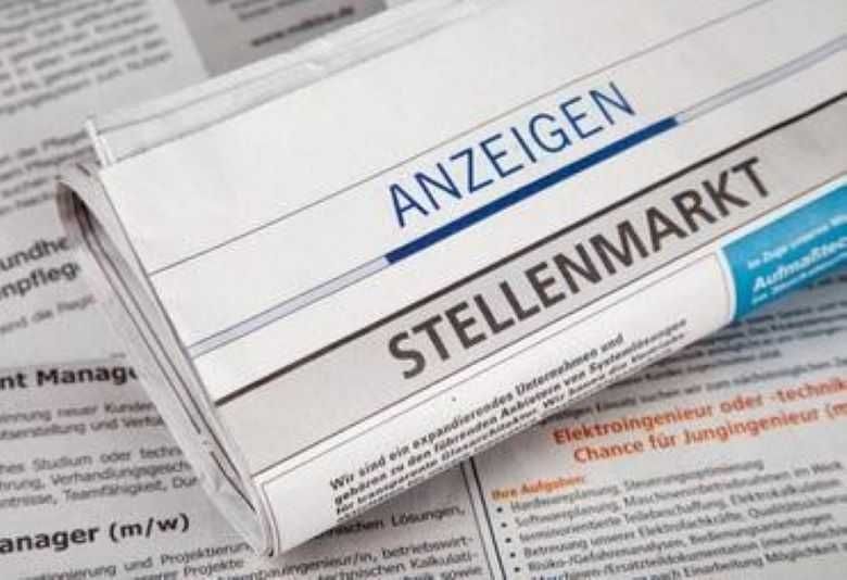 Ein Zeitungsartikel mit dem Titel 'Stellenmarkt' ist teilweise sichtbar, mit Text auf Deutsch. Der Artikel scheint sich um Stellenangebote zu drehen.