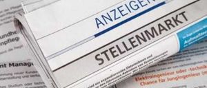 Ein Zeitungsartikel mit dem Titel 'Stellenmarkt' ist teilweise sichtbar, mit Text auf Deutsch. Der Artikel scheint sich um Stellenangebote zu drehen.