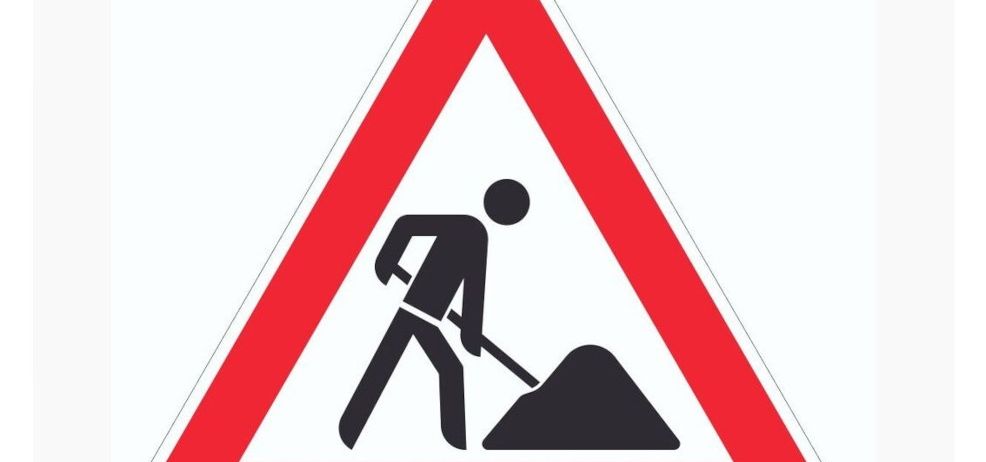 Ein Warnschild mit einer Person, die Erde schaufelt, zeigt Straßenarbeiten voraus an.