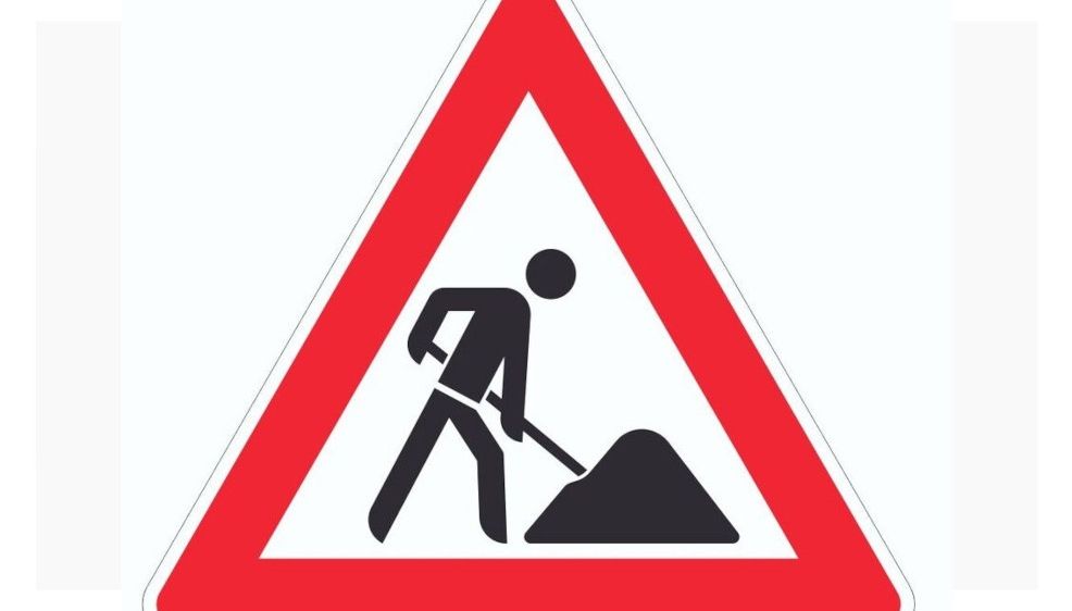 Ein Warnschild mit einer Person, die Erde schaufelt, zeigt Straßenarbeiten voraus an.