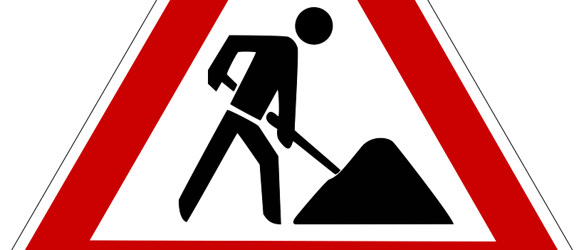 Ein dreieckiges Schild mit rotem Rand warnt vor Straßenarbeiten. Ein Umriss eines Mannes beim Graben befindet sich im Inneren des Dreiecks.