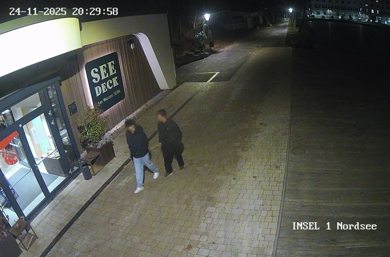 Zwei Personen gehen nachts auf einer Kopfsteinpflasterstraße vorbei an einem Schild für See Deck. Das Bild hat einen Zeitstempel von 20:29:58.