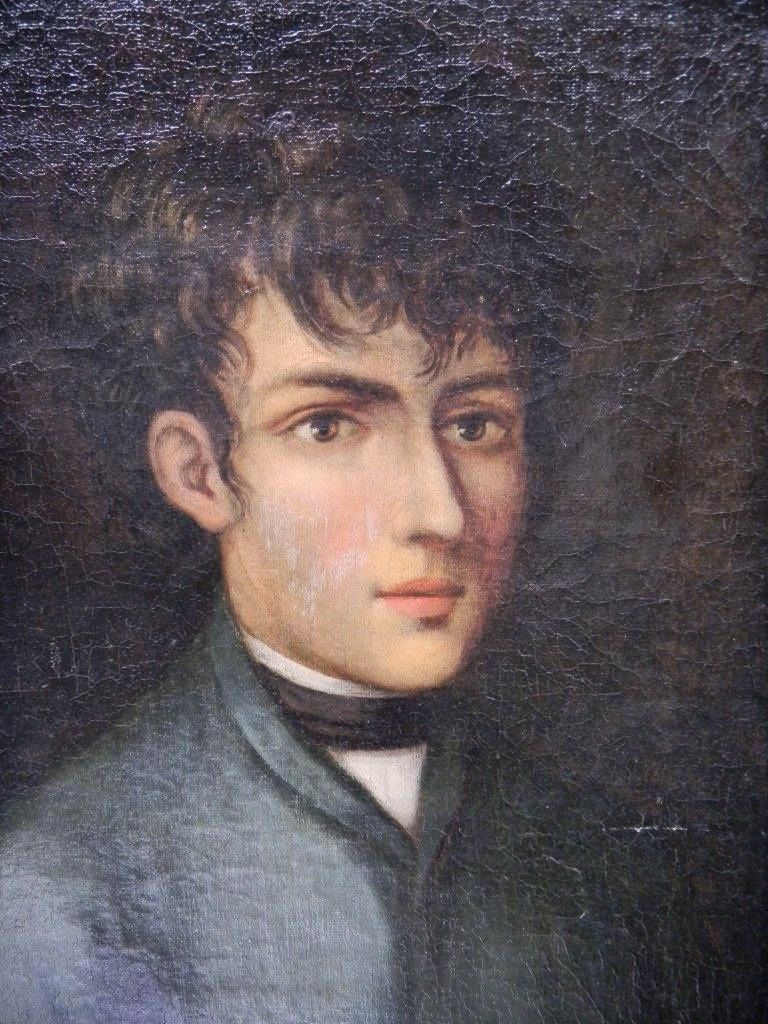 Ein Vintage-Porträt eines jungen Mannes mit kurzen lockigen Haaren, der einen formellen Anzug und eine Fliege trägt.