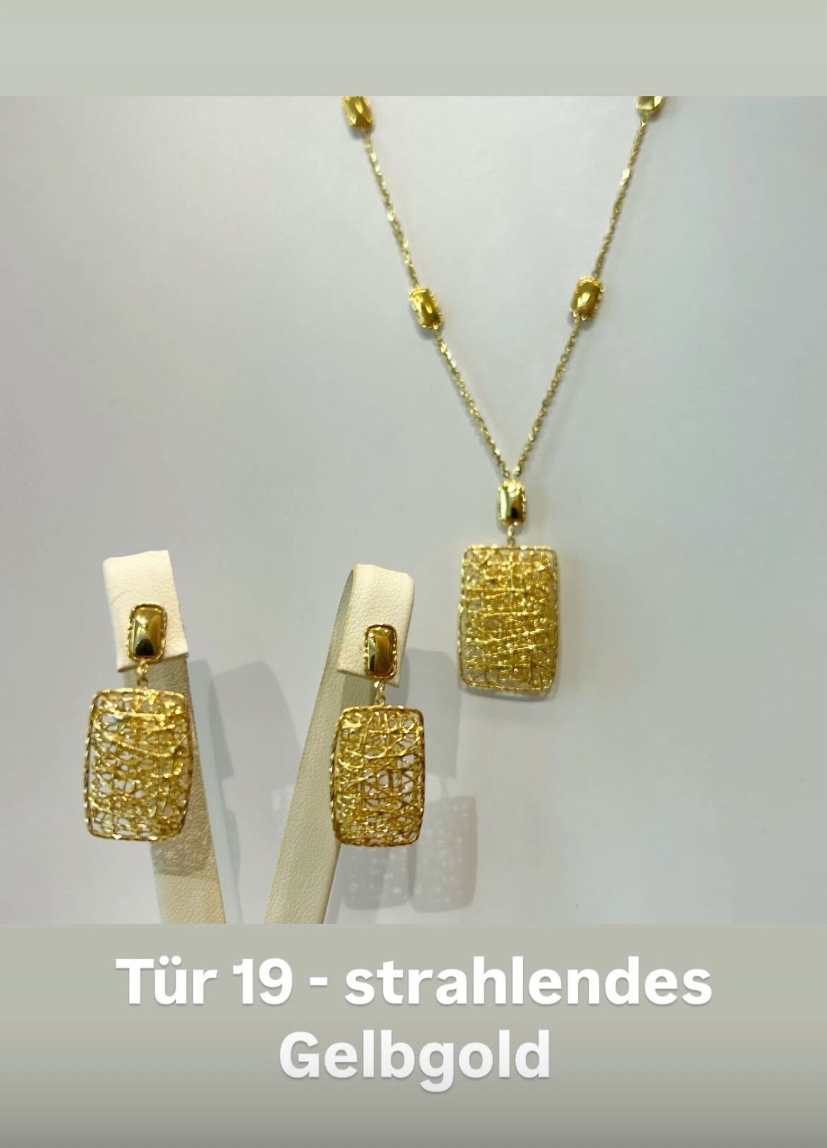 Ein Goldschmuckset besteht aus einer Halskette, zwei Ohrringen und einem Anhänger, der auf einem weißen Hintergrund präsentiert wird. Der Anhänger und die Ohrringe haben ein geometrisches Netzdesign.