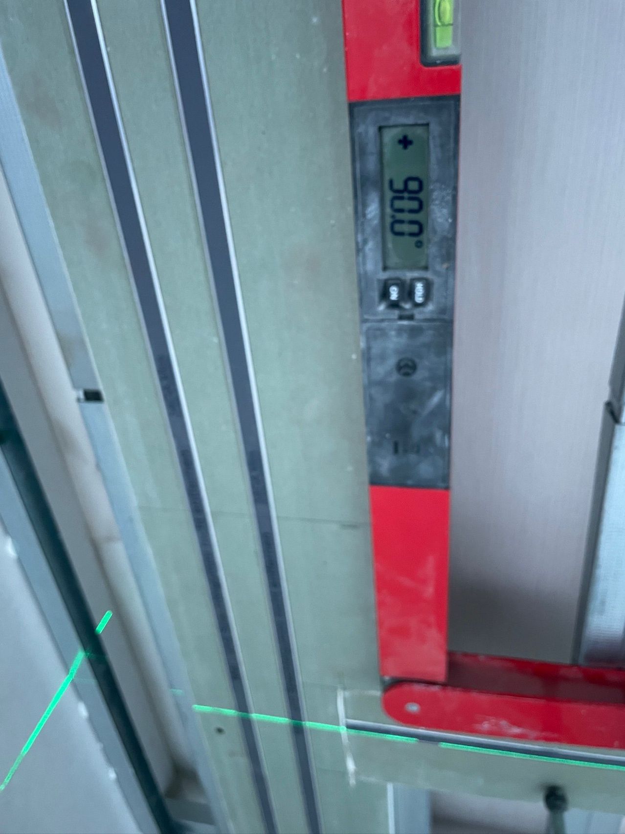 A digital temperature gauge displays 0.06 degrees Celsius. The gauge has a red handle and is mounted on a wall.