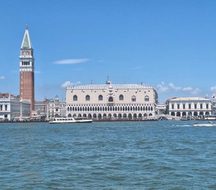 Dogenpalast Venedig mit Campanile und Wasser vor strahlend blauem Himmel