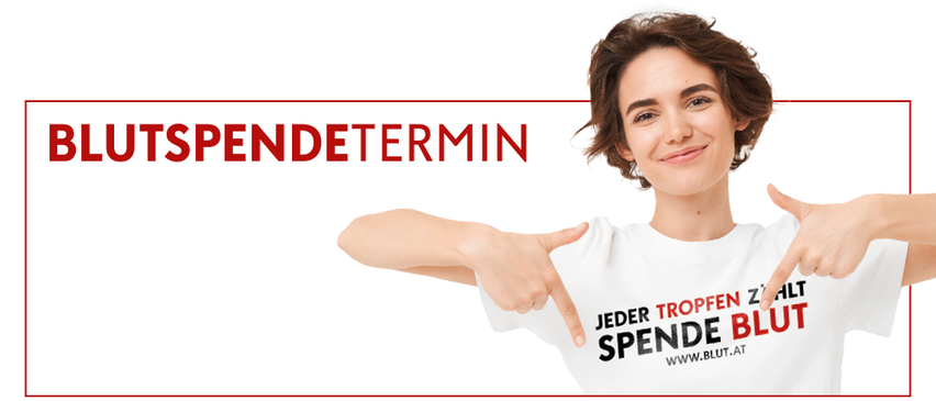 Eine lächelnde Frau zeigt mit einem ernsten Gesichtsausdruck auf ein weißes T-Shirt mit dem Text 'Jeder Tropfen Zahlt Spende Blut' und einer Website-Adresse.