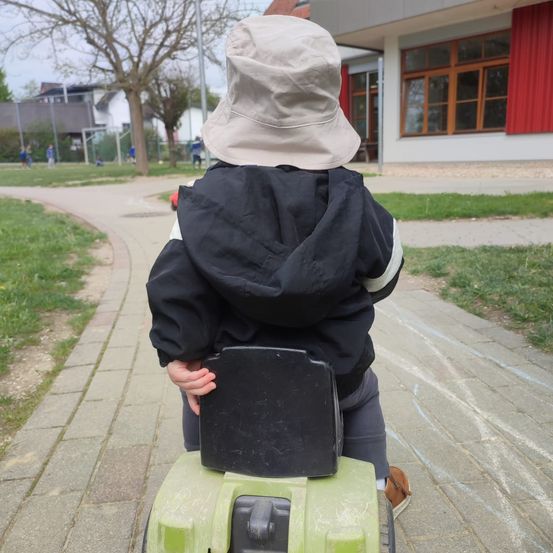 Bild enthält, Grass, City, Street, Coat, Pants, Person, Sitting, Photography, Path, Portrait