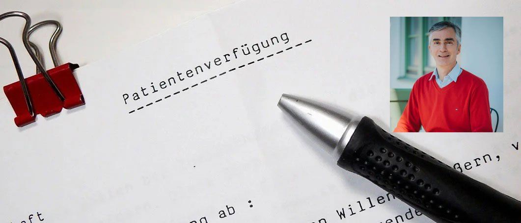 Ein Mann in einem roten Hemd hält einen Stift über ein Dokument mit dem Titel Patientenverfügung.