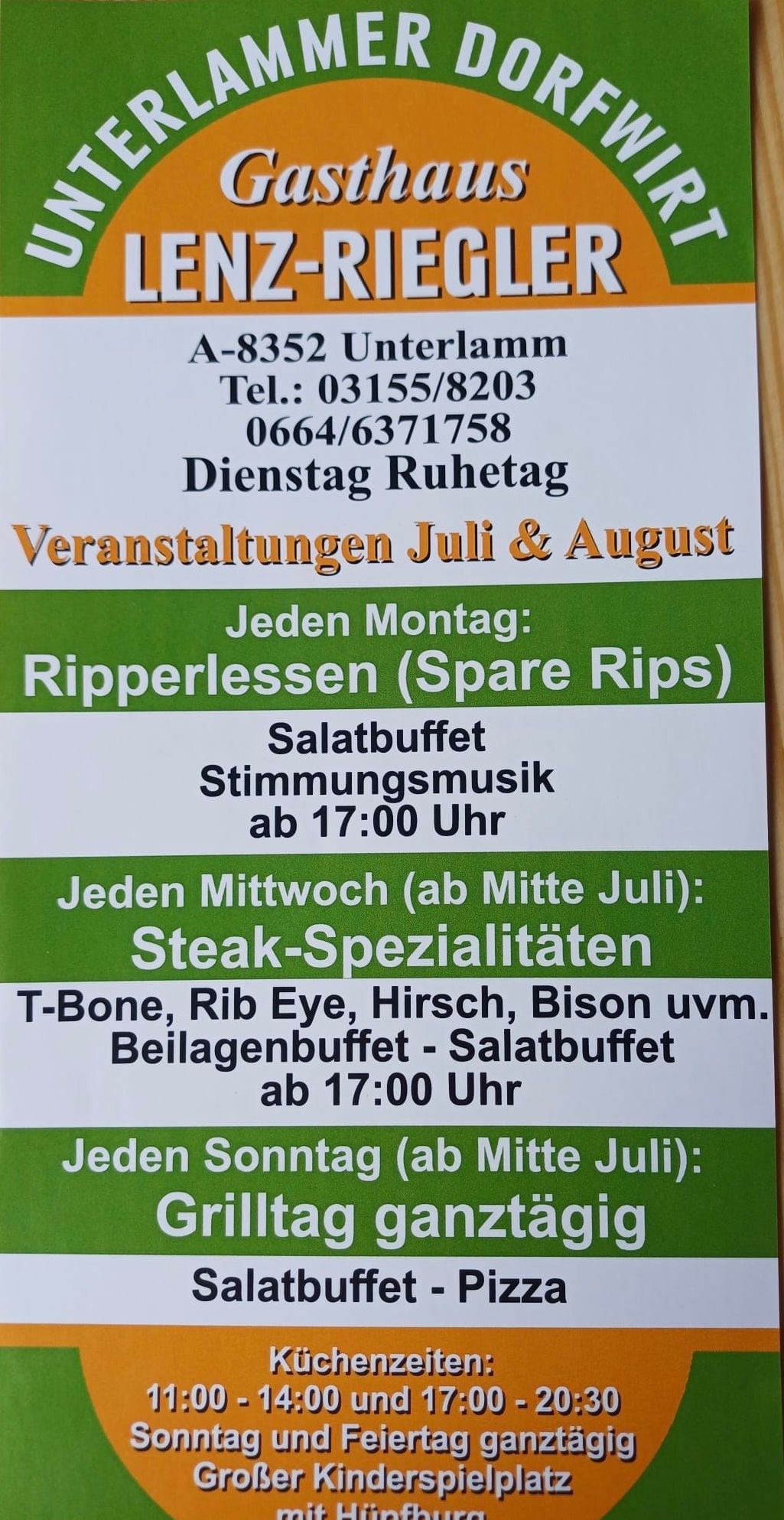 Ein Plakat bewirbt Veranstaltungen im Juli und August. Montags gibt es Ripperlessen mit Salatbuffet und Stimmungsmusik ab 17:00 Uhr. Mittwochs, ab Mitte Juli, gibt es Steak-Spezialitäten wie T-Bone, Rib Eye und mehr mit Beilagenbuffet ab 17:00 Uhr. Dienstag ist Ruhetag. Kontaktnummern sind angegeben.