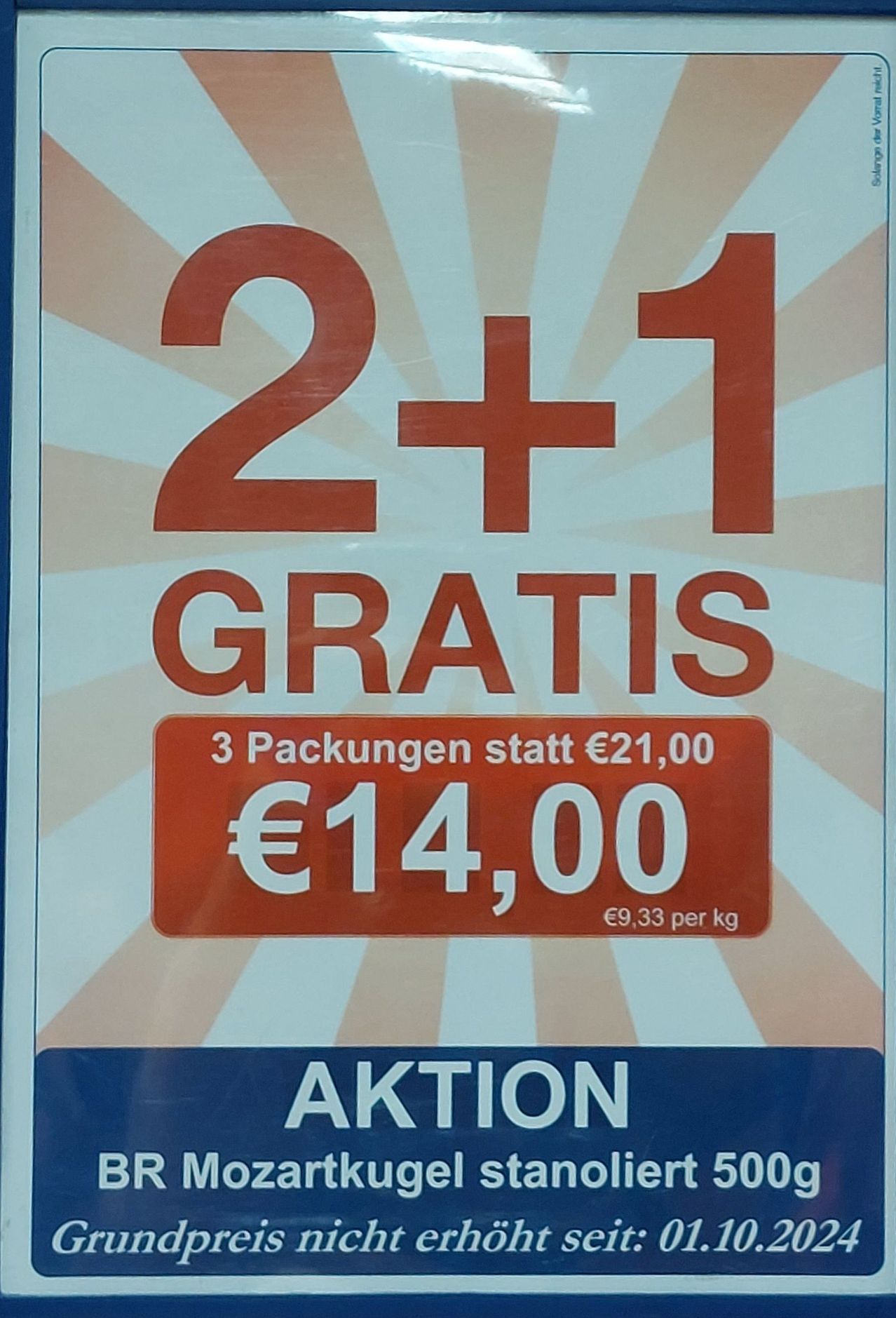 Promotional poster with red text stating '2+1 GRATIS'. Offers three packages for 14 euros instead of 21 euros. Price per kg is 9.33 euros. 'AKTION' in blue at the bottom.