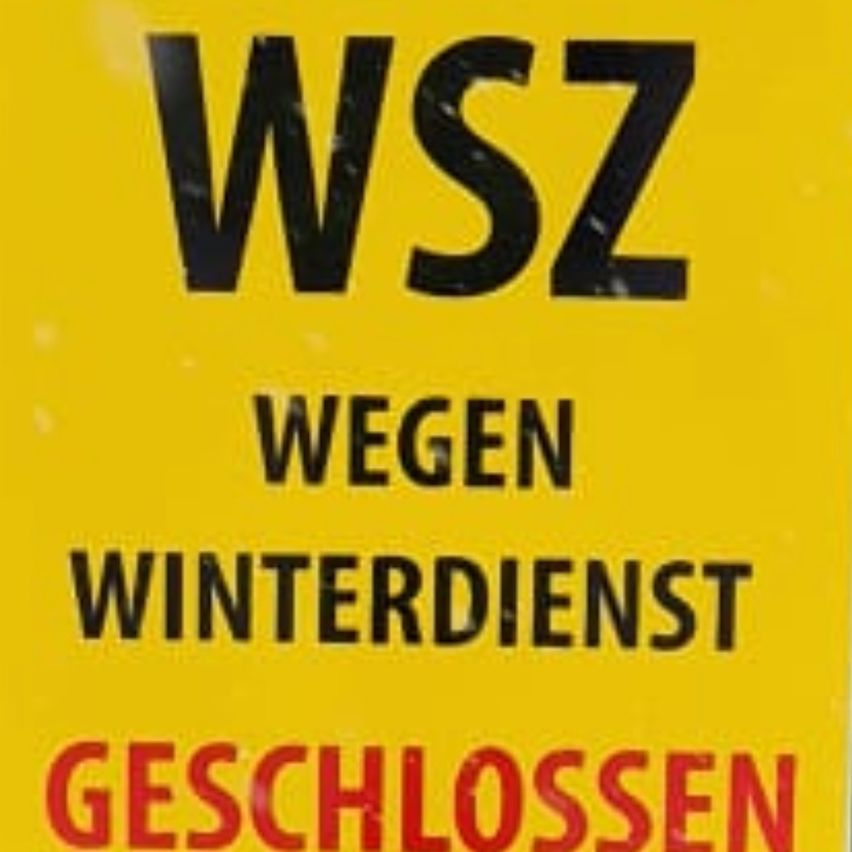 Ein gelbes Schild zeigt 'WSZ', 'WEGEN WINTERDIENST' und 'GESCHLOSSEN'. WSZ steht wahrscheinlich für einen bestimmten Bereich oder Dienst. Die Botschaft gibt an, dass es aufgrund des Winterdienstes geschlossen ist.