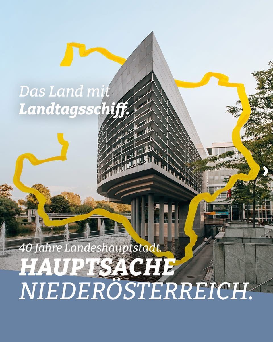 Ein Bild eines modernen Gebäudes mit einem großen gelben Band auf der linken Seite und einem Brunnen. Das Gebäude ist von Bäumen umgeben. Der Text auf Deutsch lautet 'Hauptsache Niederosterreich'.