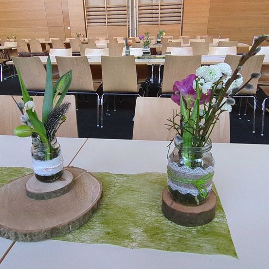 Bild enthält, Indoors, Flower, Flower Arrangement, Furniture, Table, Tape, Tabletop, Hall, Chair, People