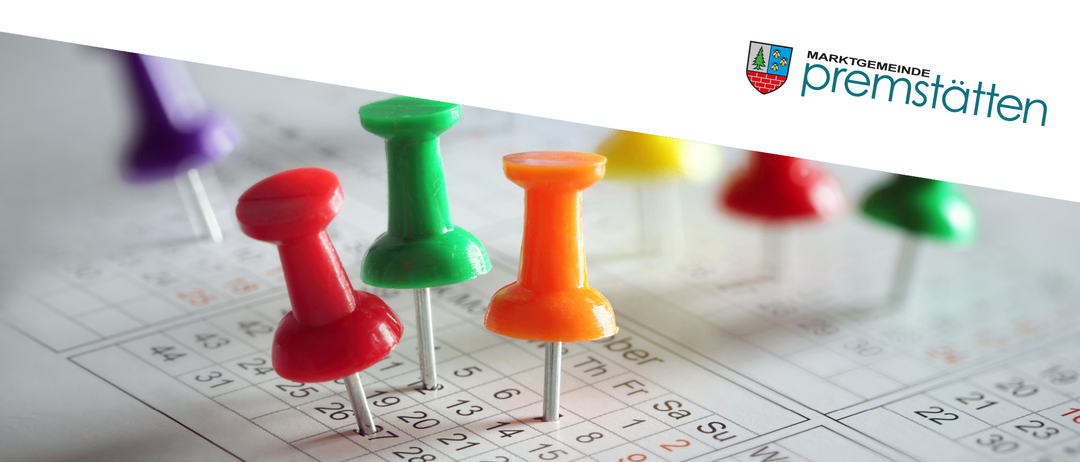 Ein Kalender mit Stecknadeln an bestimmten Tagen. Die Stecknadeln sind rot, grün und orange. Der Kalender hat Zahlen von 1 bis 31. In der oberen rechten Ecke befindet sich ein Logo.